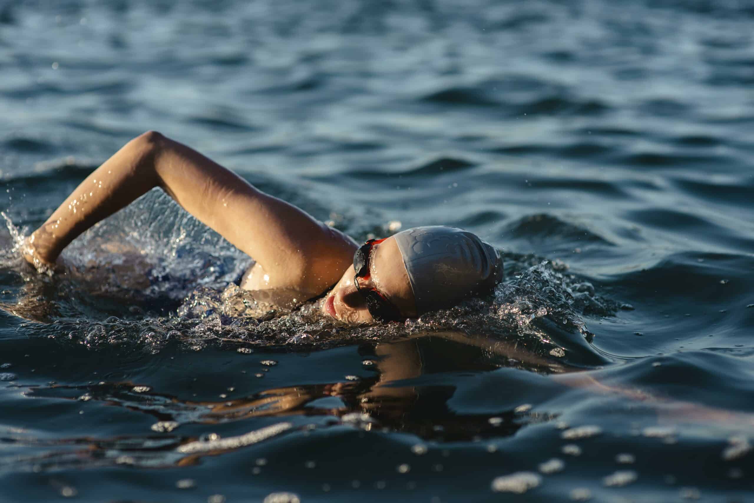 side-view-female-swimmer-with-cap-goggles-swimming-water - copie